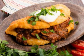 Potato pancakes with meat, vegetable, tomato and parsley