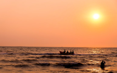 Beautiful natural view .sunset on the beach.People sitting on a boat.