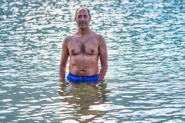 Happy man enjoying beautiful mountain lake in summer season