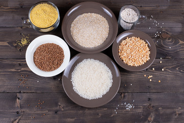 Ingredients and kitchen utensils for cooking various side dishes and porridge on a wooden table