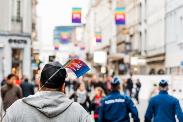 Brusseles, Belgium - May 2019: Symbol of the LGBT parade "Belgium pride" paper flag sticking out of a passer‚Äôs cap. View from the back