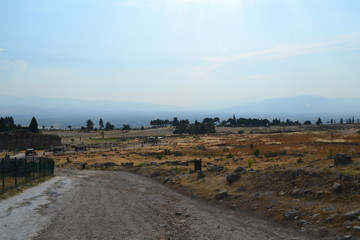 Old Hierapolis ruins, amphitheatre and touristic locations captured with hill background, in daytime.