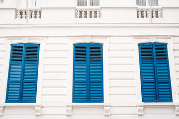 Blue shutters on an old white building. Minimalism.