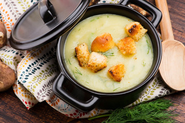 Creamy Jerusalem artichoke soup on wooden background