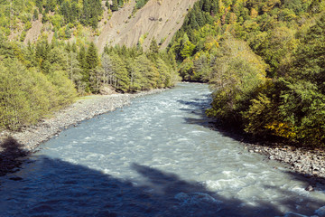A narrow  shallow winding mountain river is located in the mountainous part of Georgia
