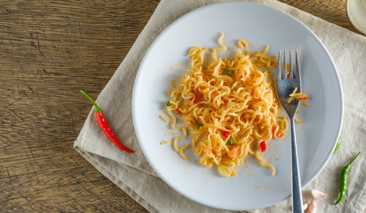 A cup of instant noodles placed on a napery With chilli as ingredients ,top view noodle and copy space