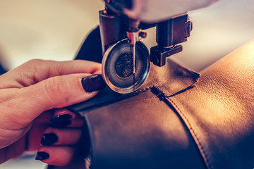 Woman hands stitching a part of the shoe at a workshop