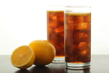 Glasses with cuba libre cocktail or cola with ice or cold tea with lemon