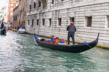 Fototapeta na wymiar Gondoliers helping tourists exploring city, Venice