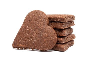 Delicious homemade chocolate and sugar cookies in the shape of hearts, piled up on top of each other and one stands nearby, isolated on a white background. Holiday baking for the whole family