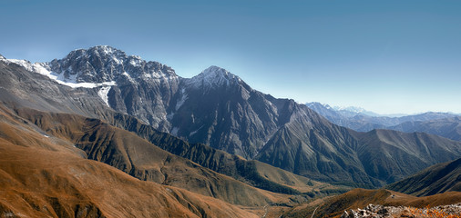 Panorama of the Caucasus Mountain Range with snowy peaks and glaciers in autumn near the village of...