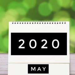 White blank paper desk spiral May calendar on wood with green abstract background. Calender of 2020 and empty month or Date to enter text and numbers.