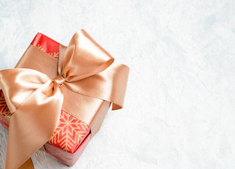 red christmas gift with golden bow on a white background