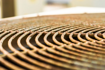 Fototapeta na wymiar top view of the grill of the fan of heavy duty central air conditioner system and sunrise in the background 