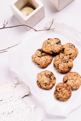 Christmas cranberry and chocolate oatmeal cookies on white background decorated birch bark, branches and candles. Selective focus