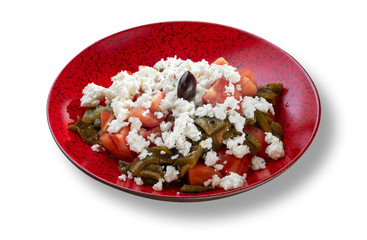 Fresh village salad with tomatoes and white cheese in modern red plate