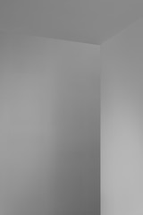 White wall corner with straight angle, lighted with a soft natural light rendering a nice shade of...