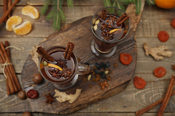 Obraz na płótnie Canvas mulled wine hot drink or tea with spices and spices on a wooden background with a branch of spruce. Traditional winter drink. Christmas concept, background, banner, menu. Top view. Flat lay.