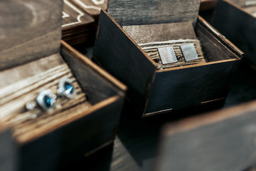 Silver men's cufflinks lie in wooden boxes