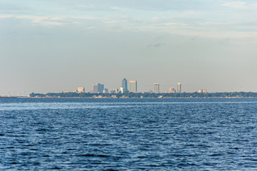 Fototapeta premium View of the city of Jacksonville, Florida, from the distance, while sailing on the Saint John's river on a sunny afternoon. United States