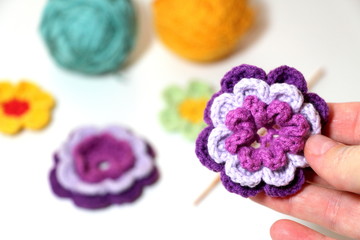 Needlework. Beautiful knitted flowers. Crochet. Violets. Purple flowers.