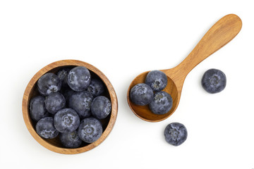 Blueberry in wooden bowl and spoon isolated on white background with copy space, fruit juicy