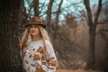 Woman of plus size, American or European appearance walks at the nature. A young lady with excess weight, stylishly dressed in warm clothes, Natural beauty