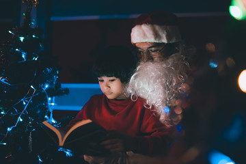 Obraz premium Santa clause reading tale for kid at christmas festival at home,Thailand people