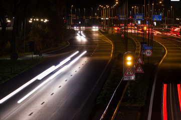 Fototapeta na wymiar Intersection at night with traffic lights and traffic blurred by motion in Arnhem, Netherlands