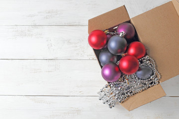 Box with Christmas decorations on a white rustic background, place for text, congratulations or...