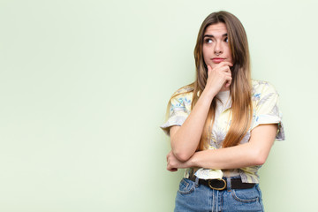 young pretty woman thinking, feeling doubtful and confused, with different options, wondering which...
