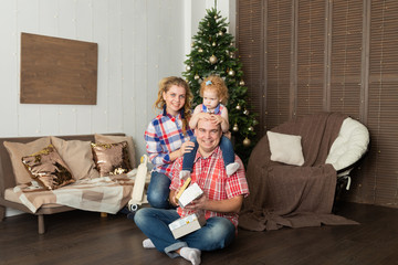 Happy family at the Christmas tree in the interior. New Year 2020.