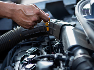 Fototapeta premium The mechanic's hand is measuring the engine oil level