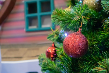 Christmas tree decorated with red ball on pine branches background