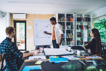 Man presenting diagram to coworkers