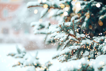 Christmas tree outdoor with snow, lights bokeh around, and snow falling, Christmas atmosphere.