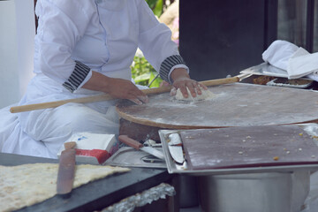 Turkish woman makes a traditional national dish - a baked flat pancake Gozleme.