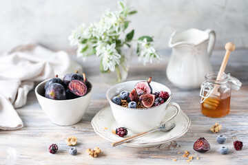 Cottage cheese with figs, berries, honey. Cup of coffee and coffee pot. Breakfast. Wooden table.