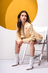beautiful girl sitting on chair on white and orange
