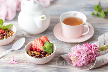 Fototapeta na wymiar Spring Breakfast with granola and fresh strawberries and lychee and flowers on wooden background.