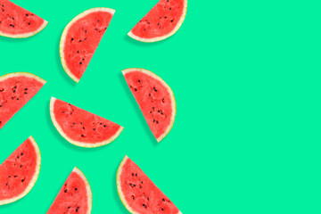 Flat lay of watermelon half slices on mint background. Watermelon pattern.