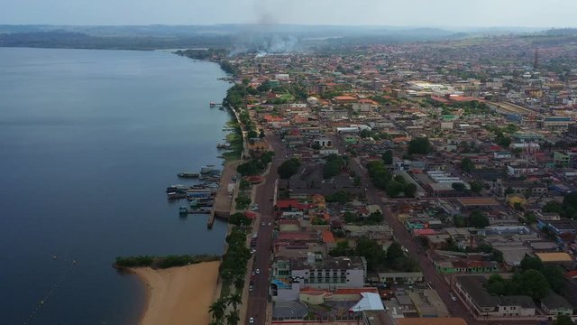 High aerial shot, city of Altamira, Brazil along the Xingu River. Fire and smoke in the distance