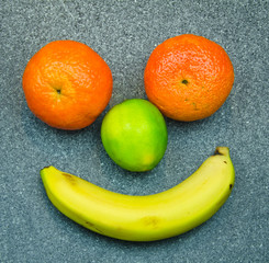 A funny face layed with fruits on a table