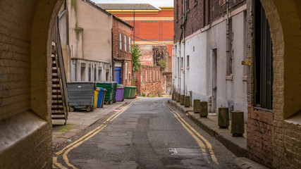 Fototapeta na wymiar A small road with garbage containers on the side, seen in Carlisle, Cumbria, England, UK