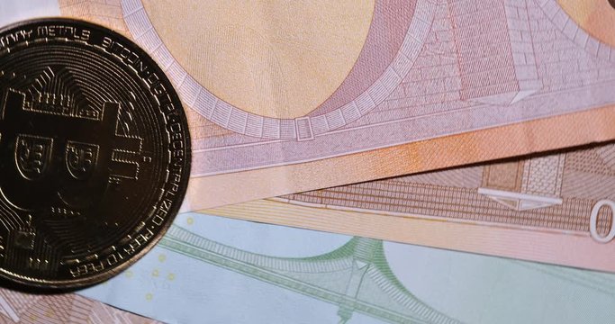 Coin with symbol of cryptocurrency of bitcoin lies on real banknotes of European Union, euro, new money, exchange of digital money for euro, fiat currency, coin, gold, new economy, rotation in space