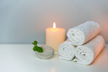 Relax in SPA concept photo with candle light, fresh towels and sea salt in a cup.