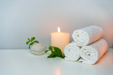 Fototapeta na wymiar SPA & Massage salon photo with fresh towels, sea salt for bath and aroma candles.