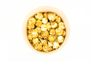 Top view of air tasty popcorn on white background. Snack for a movie, an idea for a meal. Close-up, top view. Copy space for text. Paper cup for popcorn.