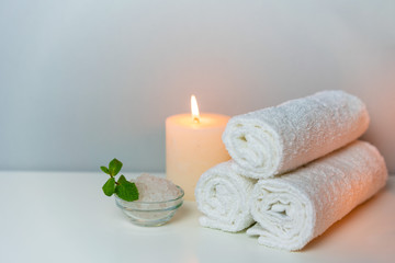 Recreation in SPA concept photo with candle, stack of towels and sea salt for bath.