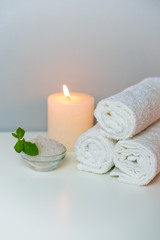 SPA&Recreation concept photo with candle, stack of towels and sea salt for bath, vertical orientation.